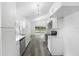 Bright kitchen featuring white cabinetry, stainless steel appliances, gray wood-look flooring, and modern lighting at 5642 Chukar Dr, Orlando, FL 32810