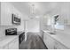 Bright kitchen featuring white cabinetry, stainless steel appliances, gray wood-look flooring, and modern lighting at 5642 Chukar Dr, Orlando, FL 32810