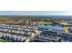 Beautiful aerial view of a community with a lake, green spaces, and various single-Gathering houses and town houses at 7184 Oakmoss Loop, Davenport, FL 33837