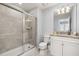 Well-lit bathroom featuring a sleek glass shower and modern granite-topped vanity at 7184 Oakmoss Loop, Davenport, FL 33837