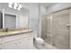 Bright bathroom with granite countertop, sleek white cabinets, and modern glass shower at 7184 Oakmoss Loop, Davenport, FL 33837