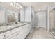 Bright bathroom features double granite vanity, tile floors and glass shower doors at 7184 Oakmoss Loop, Davenport, FL 33837