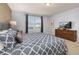Well-lit bedroom featuring a plush bed, modern decor, and a large window at 7184 Oakmoss Loop, Davenport, FL 33837