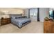 Well-lit bedroom featuring a plush bed, modern decor, and a large window at 7184 Oakmoss Loop, Davenport, FL 33837