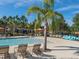 Community pool with comfortable lounge chairs, pool toys, and a serene atmosphere for relaxation at 7184 Oakmoss Loop, Davenport, FL 33837