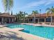 A community pool with lounge chairs, umbrellas, restrooms, and dining areas for residents' enjoyment at 7184 Oakmoss Loop, Davenport, FL 33837