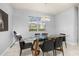 Bright dining room with a modern glass table and contemporary chandelier at 7184 Oakmoss Loop, Davenport, FL 33837