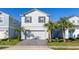 Charming two-story home featuring a well-maintained lawn and a two-car garage at 7184 Oakmoss Loop, Davenport, FL 33837