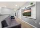 Upstairs hallway with a gray couch and mounted television set against a gray wall at 7184 Oakmoss Loop, Davenport, FL 33837