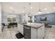 Spacious kitchen island with seating, stainless steel dishwasher, and tile flooring, and dining area at 7184 Oakmoss Loop, Davenport, FL 33837