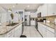 Bright kitchen featuring white cabinets, stainless steel appliances, and granite countertops at 7184 Oakmoss Loop, Davenport, FL 33837