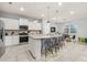 Open kitchen featuring an island with seating, stainless appliances, and tile flooring at 7184 Oakmoss Loop, Davenport, FL 33837