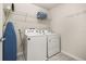 This is a laundry room with a washer, dryer, ironing board and storage shelf for convenience at 7184 Oakmoss Loop, Davenport, FL 33837