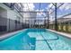 The private screened pool features sun loungers and a secure fence for relaxation and peace of mind at 7184 Oakmoss Loop, Davenport, FL 33837