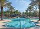 Beautiful swimming pool with waterfalls and slides, surrounded by palm trees and lounge chairs at 7184 Oakmoss Loop, Davenport, FL 33837