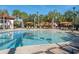 Large pool area with palm trees, lounge chairs, cabanas, and a playground at 7184 Oakmoss Loop, Davenport, FL 33837
