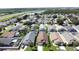Panoramic aerial of a community featuring homes with screened pools, mature trees, and a highway in the background at 8019 Indian Creek Blvd, Kissimmee, FL 34747