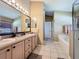 Bathroom features a double vanity with a large mirror and tile floors at 8019 Indian Creek Blvd, Kissimmee, FL 34747