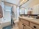 Bathroom with a tub-shower, a large mirror, and vanity with light beige cabinet at 8019 Indian Creek Blvd, Kissimmee, FL 34747