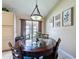 Cozy dining area with a round glass-top table and views of the landscaped outdoors at 8019 Indian Creek Blvd, Kissimmee, FL 34747