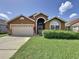 Well-maintained single-Gathering home with a manicured lawn and large driveway at 8019 Indian Creek Blvd, Kissimmee, FL 34747