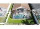 Aerial shot of a screened-in pool with clear blue water, surrounded by a green lawn and privacy fence at 8019 Indian Creek Blvd, Kissimmee, FL 34747