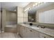 Elegant bathroom featuring double granite vanity, oversized mirror, and separate tub at 8601 Worldquest Blvd # B1/U3502, Orlando, FL 32821