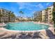 A large community pool surrounded by palm trees and lounge chairs providing a resort-style experience at 8601 Worldquest Blvd # B1/U3502, Orlando, FL 32821
