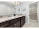 Elegant bathroom featuring double sinks, granite countertops, and a glass-enclosed shower at 971 Paradise Dr, Davenport, FL 33897