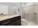 Modern bathroom featuring a dark vanity with granite countertop and a glass-enclosed shower at 971 Paradise Dr, Davenport, FL 33897