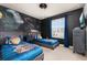 Themed bedroom featuring custom wall art, twin beds, and dark accent walls at 971 Paradise Dr, Davenport, FL 33897