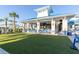 Exterior view of the clubhouse featuring covered seating, large screen televisions and an expansive artificial turf lawn at 971 Paradise Dr, Davenport, FL 33897