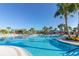 Expansive community pool with lounge chairs and swaying palm trees, offering a luxurious resort-style atmosphere for residents at 971 Paradise Dr, Davenport, FL 33897