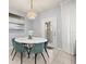 Cozy dining area with a marble-top table, six chairs, elegant light fixture and view of the home's entry at 971 Paradise Dr, Davenport, FL 33897