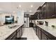 Modern kitchen with granite countertops, stainless steel appliances, and stylish dark cabinetry at 971 Paradise Dr, Davenport, FL 33897