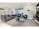 Bright living room featuring a modern couch, plush chairs and view of the screened-in lanai and backyard at 971 Paradise Dr, Davenport, FL 33897