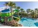 Awesome colorful water slides by the pool in a lush tropical paradise surrounded by palm trees under a blue sky at 971 Paradise Dr, Davenport, FL 33897