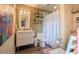 Bathroom with modern vanity, decorative shelving, and a shower behind a patterned white curtain at 987 Trumbull St, Deltona, FL 32725
