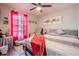 Comfortable bedroom with a ceiling fan, bright windows, and colorful modern art at 987 Trumbull St, Deltona, FL 32725
