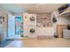 Laundry room with stacked washer and dryer, cabinets, and access to the backyard at 987 Trumbull St, Deltona, FL 32725