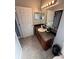 Functional bathroom featuring wood vanity, granite countertop, with large mirror and neutral tile flooring at 1029 Dampierre Ct, Kissimmee, FL 34759