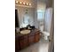 Bathroom featuring a dark wood vanity, stylish lighting, and tub with shower, offering comfort and functionality at 1029 Dampierre Ct, Kissimmee, FL 34759