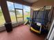 Enclosed patio with trampoline, and view of the backyard, perfect for relaxation and play at 1029 Dampierre Ct, Kissimmee, FL 34759
