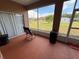 Enclosed patio with rocking chair, table, trash can, and a view of the backyard at 1029 Dampierre Ct, Kissimmee, FL 34759
