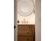 Charming bathroom showcasing a curved wood vanity, gold hardware, and decorative round mirror at 1047 Banks Rose St, Kissimmee, FL 34747