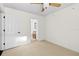 This bedroom has a carpet, ceiling fan, window with blinds, and a door leading to the bathroom at 1047 Banks Rose St, Kissimmee, FL 34747