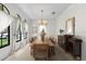 Formal dining room featuring a long wooden table, elegant chandelier and lots of light at 1047 Banks Rose St, Kissimmee, FL 34747