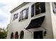 Elegant white house exterior featuring black shutters, an awning, and arched windows at 1047 Banks Rose St, Kissimmee, FL 34747