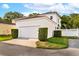 Exterior view of a white two story home with a two car garage and green landscaping at 1047 Banks Rose St, Kissimmee, FL 34747