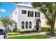 Charming white two-story home with black shutters, arched windows, and lush landscaping at 1047 Banks Rose St, Kissimmee, FL 34747